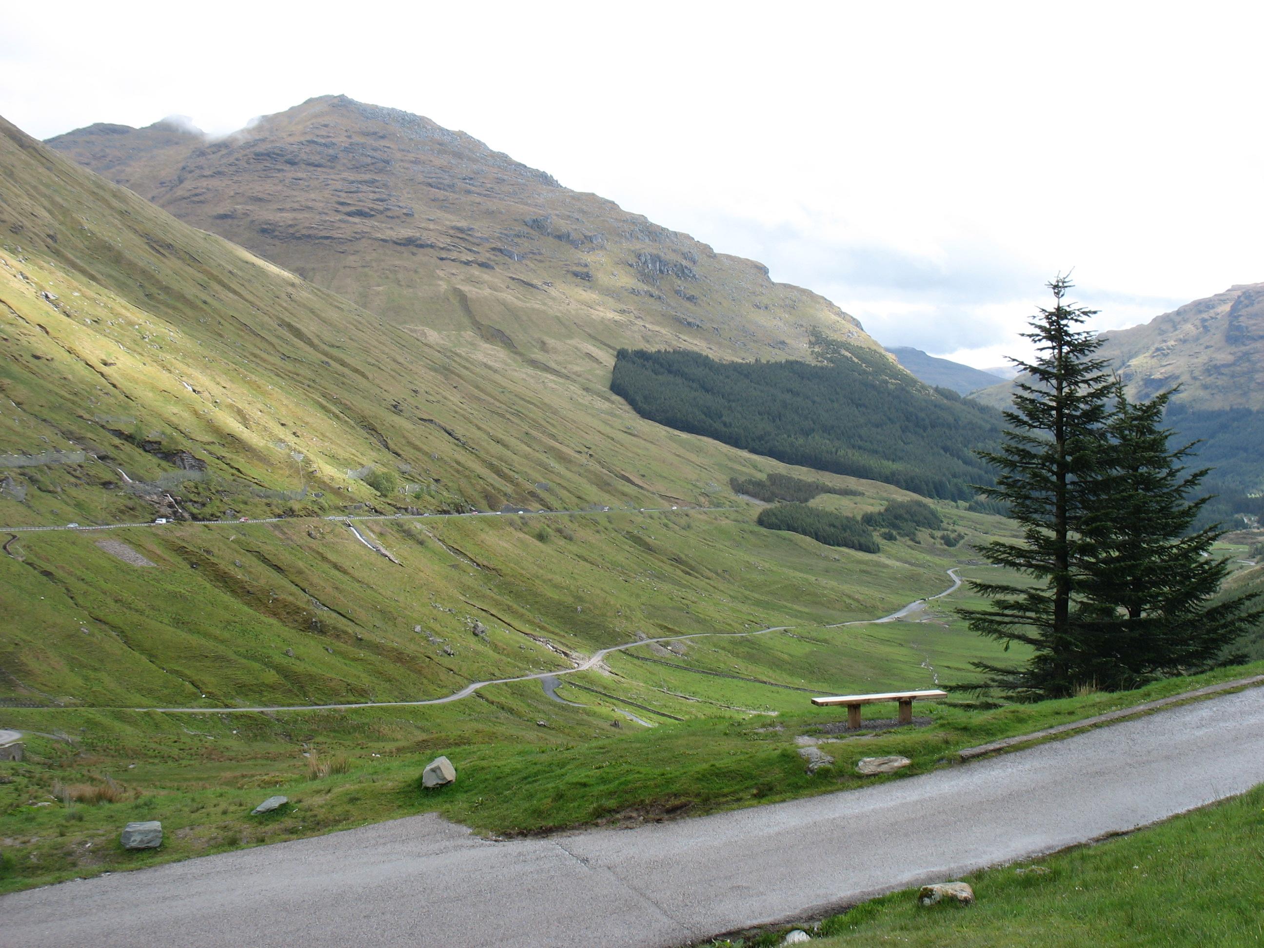 Roads winding through the green mountain valley below Rest and Be Thankful