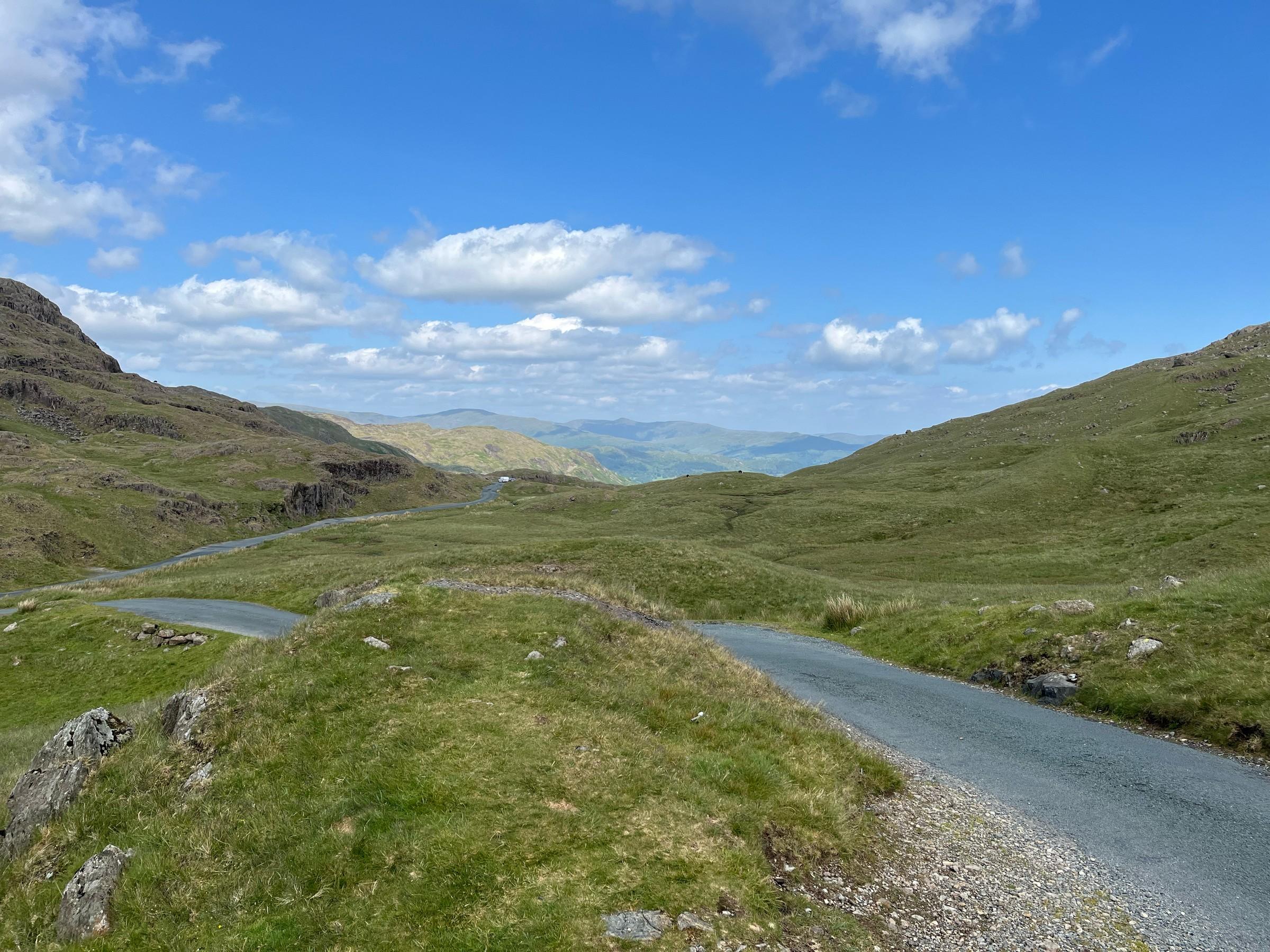 The narrow road winding across open fell terrain at Wrynose Pass